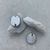 Aros colgantes circulares con apliques de nácar, bronce dorado y alpaca plateada.