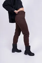 Pantalón mom jean color beige, de tiro alto, con bolsillos delanteros y traseros, y ruedo doblado.