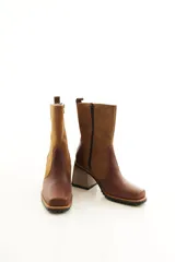 Bota de caña media combinada en cuero liso y descarne color marrón, con punta cuadrada, cierre lateral y taco ancho de madera.