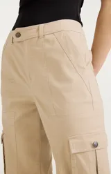 Pantalón cargo color beige de tiro alto, con bolsillos laterales con solapa y ajuste con lazos en los tobillos.