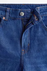 Jean de cinco bolsillos en denim de algodón lavado, de tiro alto con piernas rectas de corte holgado y cierre con botón.