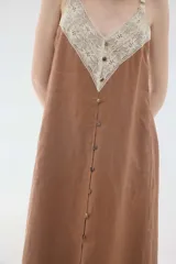Vestido midi lencero marrón de lino, con escote en V pronunciado con aplique de encaje en contraste, breteles regulables y botonadura frontal decorativa.