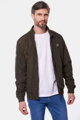 Campera liviana de color verde grisáceo, con cierre frontal, cuello alto y puños elásticos. Presenta un pequeño parche con logo en el pecho.