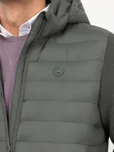 Chaqueta híbrida para hombre con frente acolchado de nylon y mangas de tejido de punto. Cuenta con cierre frontal, capucha y puños acanalados.