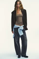 Blazer oversize de corte recto con estampado de raya diplomática. Presenta cuello con solapa, cierre frontal cruzado con botones, hombros caídos y bolsillos delanteros con vivo.