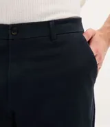 Pantalón de corte recto confeccionado en sarga de algodón con un toque de elastano. Presenta cintura con trabillas para cinturón, cierre tradicional de botón y cremallera, y bolsillos laterales y traseros.