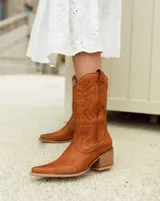 Bota texana blanca de cuero con bordados decorativos y taco de madera.