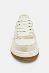Zapatillas deportivas de cuero color beige y blanco, con suela marrón de goma y cierre con cordones.