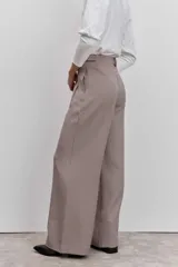 Pantalon de vestir de corte sastrero y pierna ancha, con estampado de cuadros tipo príncipe de gales en tonos tierra. Presenta cintura alta con trabillas, cierre frontal con botones y bolsillos laterales con detalle de ribete.