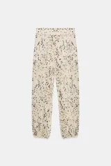 Pantalón de tiro medio con estampado de manchas, bolsillos delanteros y bajo con puño elástico. Incluye forro interior.