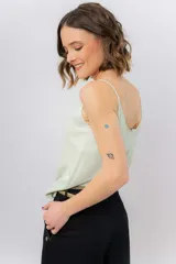 Musculosa de breteles finos con escote en V, confeccionada en tejido fluido con acabado satinado.