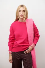 Buzo de punto color fucsia, con cuello redondo y mangas largas.