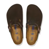 Zueco Birkenstock modelo Boston, confeccionado en gamuza color marrón oscuro. Presenta una tira ajustable con hebilla metálica en tono cobre y plantilla anatómica de corcho.