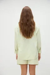 Camisa de manga larga de algodón, con diseño a rayas en tonos azules y morados, calce holgado, cuello camisero, cierre frontal con botones y un bolsillo aplicado en el pecho.