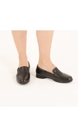 Mocasines negros de cuero, con textura de piel de reptil en los laterales y empeine liso con detalle de tira horizontal. Tienen un tacón bajo de aproximadamente 2 cm.