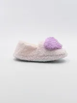 Pantuflas cerradas de tela peluda color rosa con aplique de pompón fucsia.