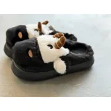 Pantuflas de peluche con diseño de vaca, confeccionadas en piel sintética suave. Cuentan con suela de goma antideslizante y diseño abierto en el talón.