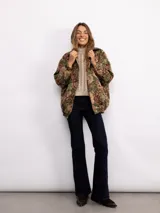Campera tipo bomber con estampado floral estilo tapicería en tonos oscuros, con cuello clásico, cierre frontal con botones metálicos y bolsillos laterales.