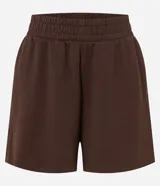 Bermuda deportiva femenina color marrón, confeccionada en modal, con cintura elástica y detalle de pliegues.
