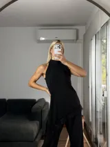 Musculosa de cuello alto con diseño irregular y bajo asimétrico, confeccionada en tela tipo cey con detalle de puntilla en el ruedo.
