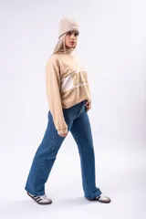 Buzo oversize de algodón color beige, con cuello polo y cierre frontal parcial. Presenta una franja horizontal blanca en el pecho con el texto 'SOHO' estampado en color beige.