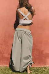 Pantalón culotte de tiro medio con cintura elástica, bolsillos laterales ocultos y bajo con abertura ajustable mediante cordones laterales.