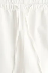 Pantalón de corte holgado en denim liviano de mezcla de lyocell y algodón. Modelo de tiro alto con elástico revestido y cordón para ajustar en la cintura, bolsillos laterales discretos y piernas rectas.