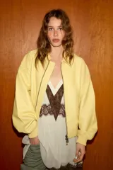 Cazadora tipo bomber de corte oversize confeccionada en piel 100% color amarillo pastel. Presenta cuello clásico, cierre frontal con cremallera metálica, bolsillos delanteros con solapa y acabados en tejido rib en puños y ruedo.