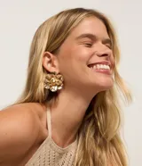 Aros dorados con forma de flor con pétalos texturizados y centro con una perla.