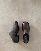 Zuecos marrones de cuero sintético con suela y taco cuadrado negros.