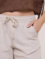 Short de lino marca Dash, color beige, con pretina ancha elastizada, lazo de ajuste, bolsillos delanteros inclinados y bolsillos aplicados en la parte trasera.