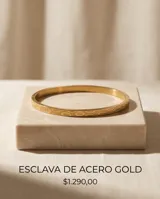 Pulsera tipo esclava rígida de acero con baño de oro, con diseño grabado en su superficie.
