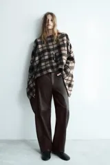 Pantalón de tiro medio confeccionado en piel 100%, con diseño de corte recto, cintura con trabillas, bolsillos delanteros y traseros, y cierre frontal con cremallera, botón y ganchos metálicos.
