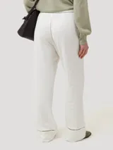 Pantalon de corte recto y tiro alto, confeccionado en una mezcla de lino orgánico y viscosa. Presenta detalles de calado decorativo en la cintura y en el ruedo de las piernas.