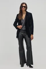 Blazer negro de pana gruesa con lurex plateado, corte boxy, cierre de un botón, bolsillos frontales y mangas largas.