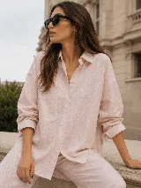 Camisa oversize de lino, color beige, con cuello camisero clásico, cierre frontal con botones, mangas largas con puños abotonados y bolsillo frontal aplicado.