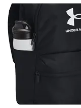 Mochila Under Armour Essntl Lite de color negro, diseñada con tecnología UA Storm resistente al agua. Cuenta con un compartimento principal con cremallera, bolsillo frontal con cierre, bolsillo lateral para botella y asa superior.