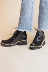 Botines negros de cuero con cordones, caña baja y taco cuadrado.