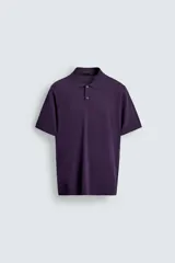 Polo de manga corta en color morado, con cuello solapa y cierre frontal de dos botones. Presenta un diseño de estructura tejida con acabados en rib en el cuello, mangas y ruedo.