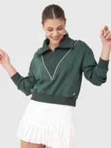 Buzo de medio cierre color verde oscuro con cuello polo y detalle de ribete blanco en forma de V. Presenta puños y cintura acanalados, con mangas largas de diseño holgado.