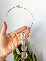 Gargantilla rígida plateada con dije colgante de cuatro piezas irregulares con textura.