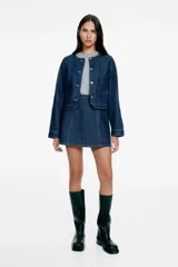 Pollera mini evasé de denim azul oscuro, con costuras pespuntadas a contratono y corte ligeramente acampanado.