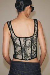 Corset confeccionado en poliamida con diseño de encaje floral y varillas estructuradas visibles. Presenta escote recto, tirantes anchos y forro interior en tono contrastante.