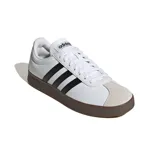 Championes Adidas modelo VL Court, de color blanco con las tres tiras clásicas en negro y suela de goma marrón. Presenta puntera reforzada en gamuza gris claro y cordones blancos.