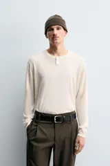 Jersey de punto con mezcla de algodón y cashmere, de corte regular y manga larga. Presenta cuello redondo con cierre frontal de dos botones y acabados en rib.