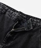 Pantalón de jean negro, estilo baggy, con bolsillos cargo laterales y efecto lavado.