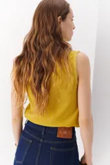 Musculosa color crema de tejido de lino con cuello redondo y sisas anchas.