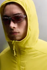 Chaqueta acolchada Zara Athleticz de color amarillo, confeccionada en tejido técnico y ligero. Cuenta con cuello subido y capucha, manga larga con puños elásticos, bolsillos frontales con cierre de cremallera oculta y cierre frontal con cremallera.