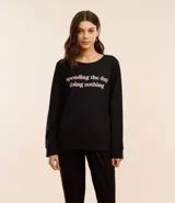 Blusa de pijama negra de algodón con cuello redondo, mangas largas y estampa frontal con la frase "spending the day doing nothing".