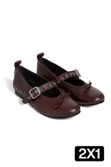 Chatas de cuero color chocolate, con punta redondeada, tira sobre el empeine con hebilla plateada y pequeño moño decorativo en la punta.